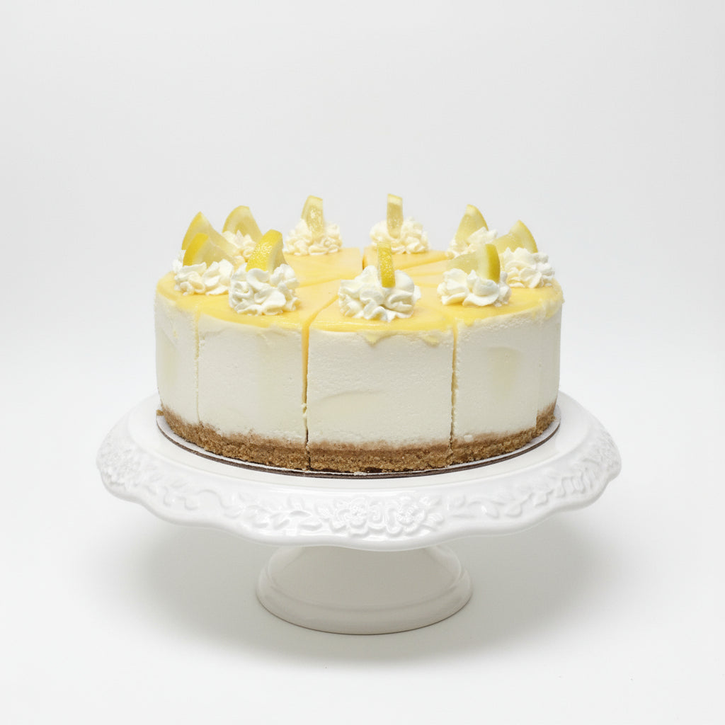 Lemon cake with white frosting and lemon slices on a black background