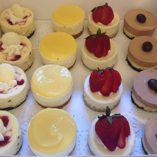 Assorted small cakes with different toppings in a box