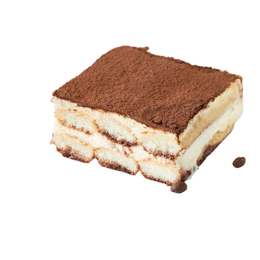 Slice of tiramisu on a white plate with coffee beans on a beige background