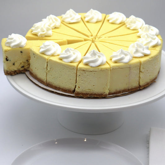 Cheesecake with whipped cream on a white stand against a white background