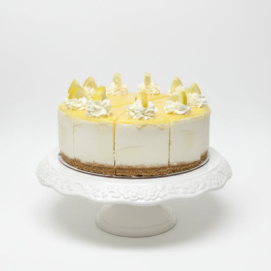 Lemon cake with white frosting and lemon slices on a black background